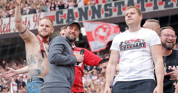 Ungewohnter Abstecher in die Cannstatter Kurve: VfB-Trainer Sebastian Hoeneß folgt den Rufen der Fans und klettert auf den Zaun.